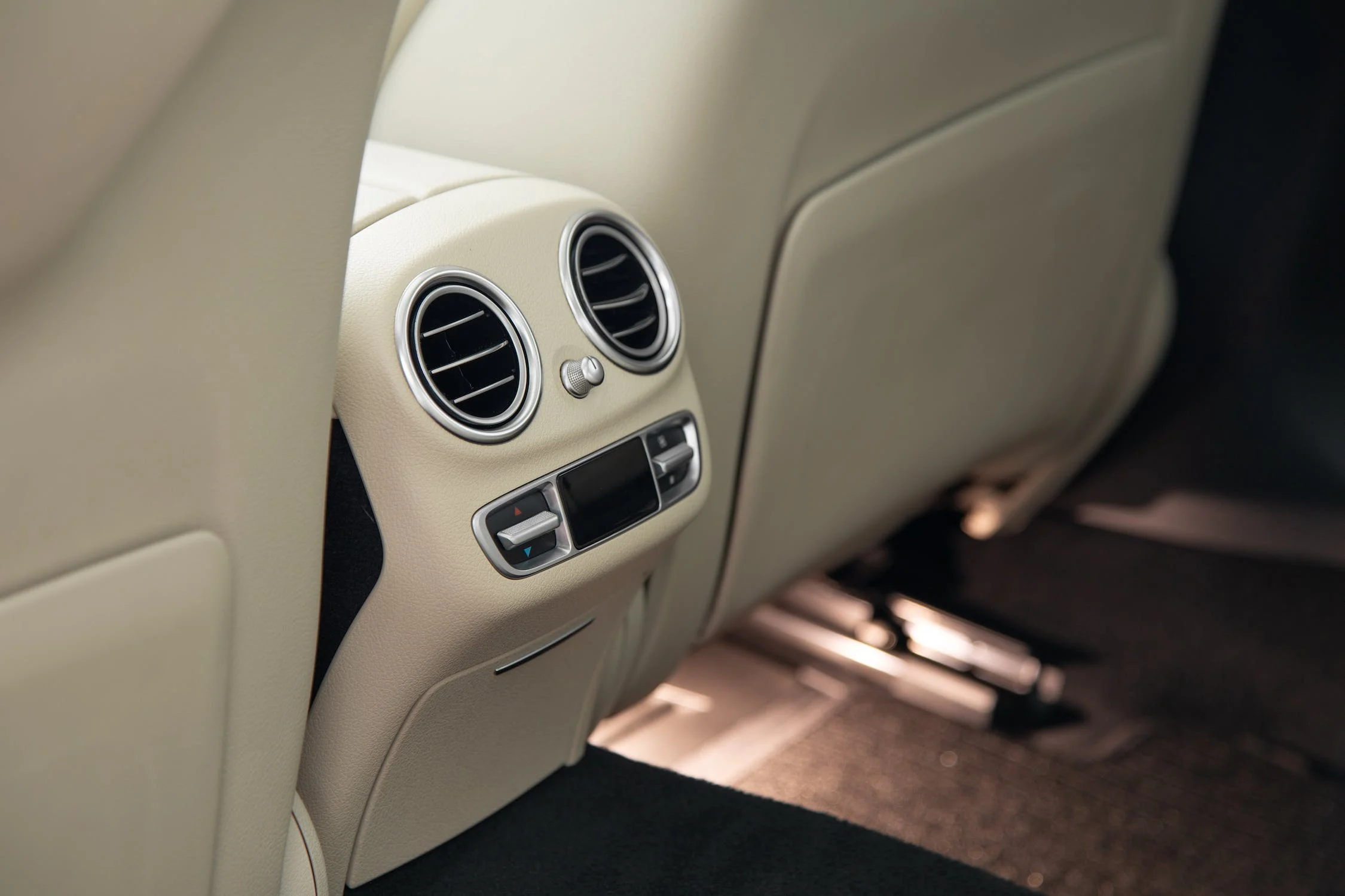 výstup klimatizace pro pasažéry na zadních sedadlech luxusního vozu s interiérem v bílé kůži